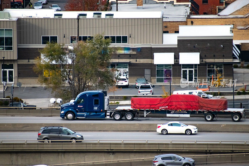 美国华盛顿州斯波坎市，90号州际公路上，System Transport半挂车拉着一辆平板拖车，车上装着油布。